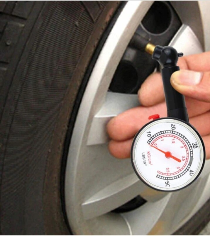 Đồng hồ cơ đo áp suất lốp có van xả đang gắn vào van bánh xe