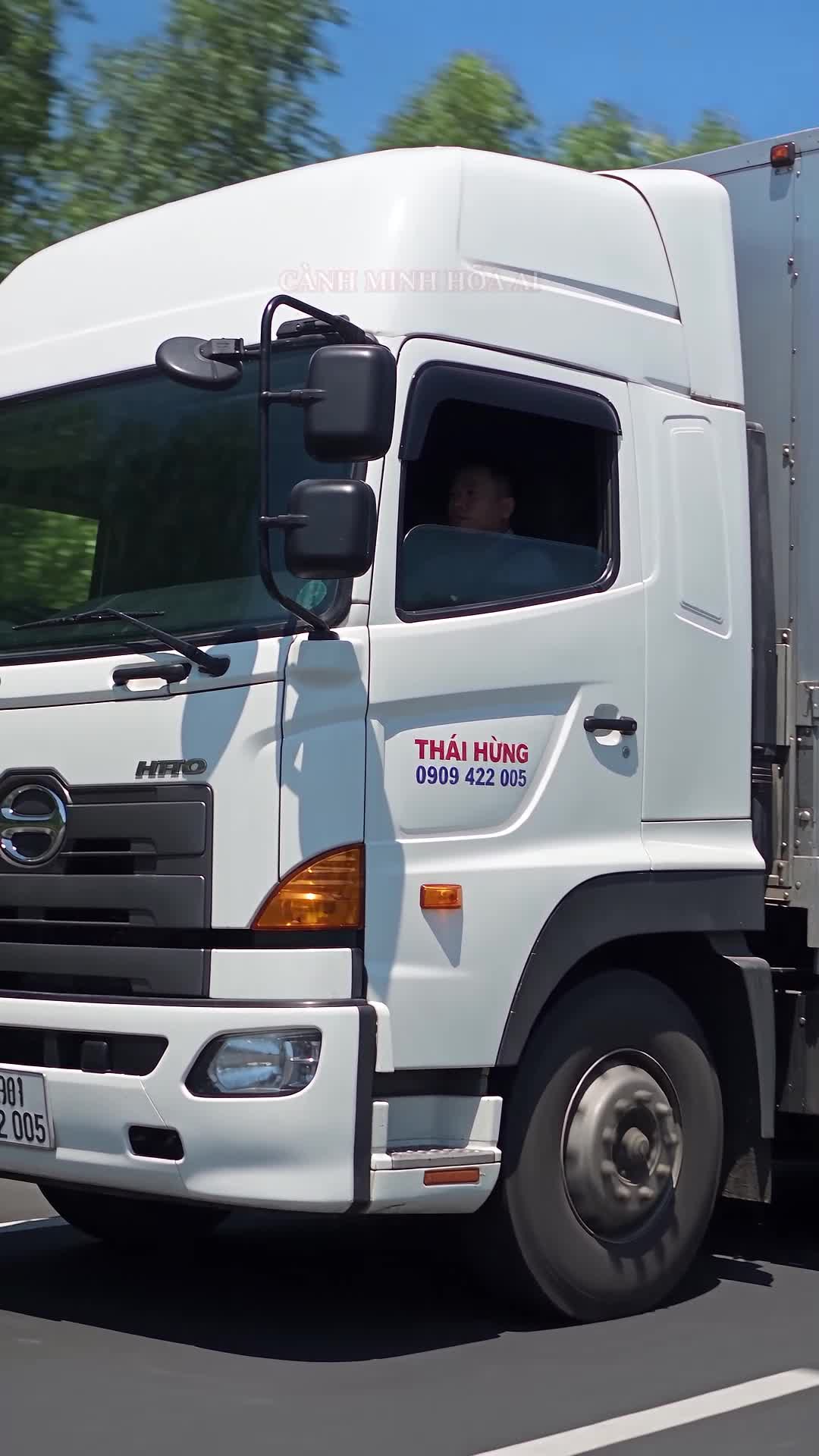 Xe tải cabin trắng có nhận diện Thái Hùng và hotline 0909 422 005, hình minh họa AI cho bản tin lưu lượng cao tốc Bắc Nam